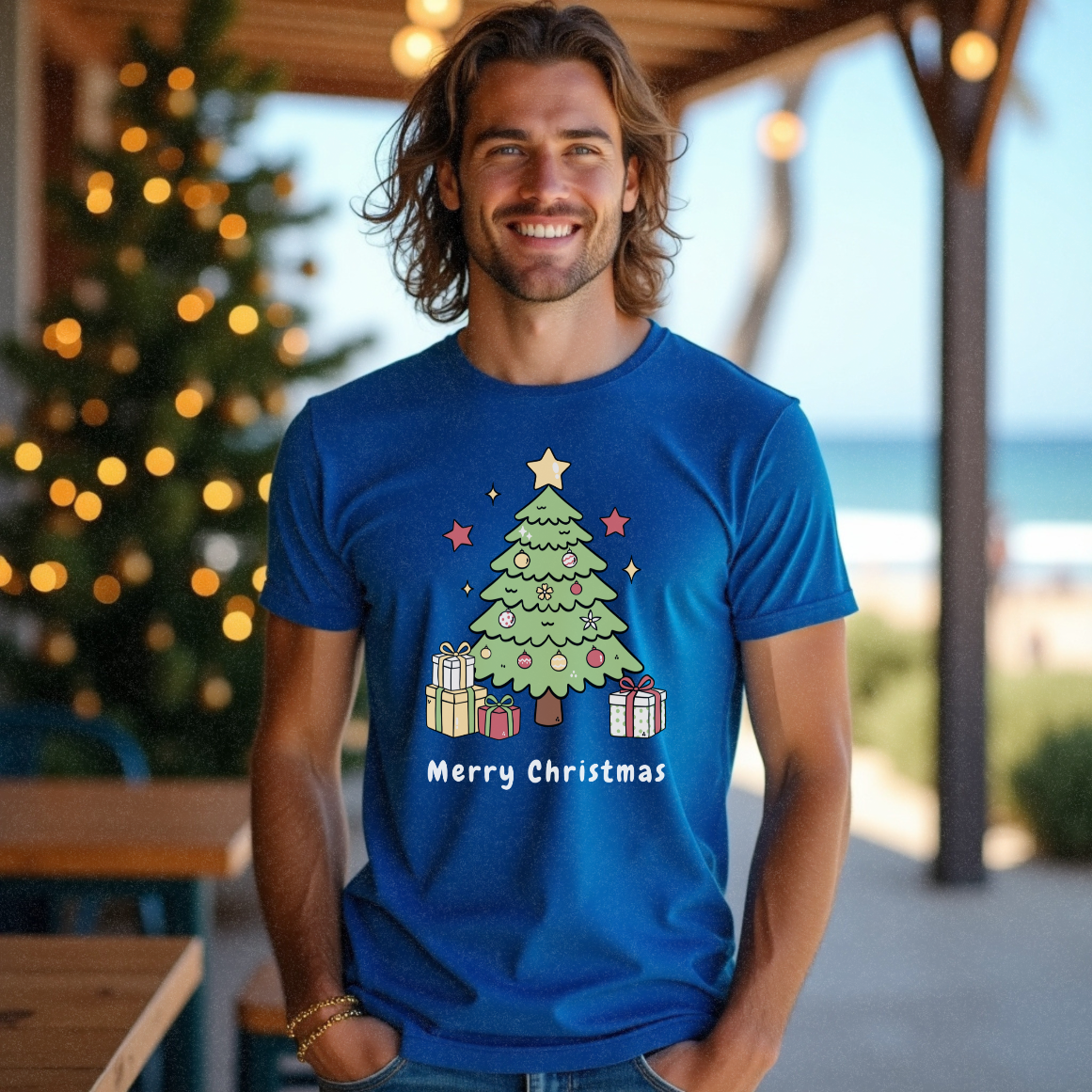 Surfer guy near the beach and a cafe short brown hair wearing an electric blue t-shirt with a cartoon image of a Christmas tree with presents at the bottom and 'Merry Christmas' underneath the graphic by Faith Looks Good