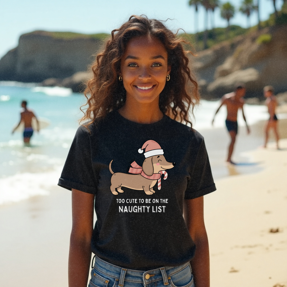 Young surfer model with long wavy brunette hair wearing a funny Christmas design of a dog in a Christmas hat on a black t-shirt that says 'Too Cute To Be On The Naughty List' by Faith Looks Good